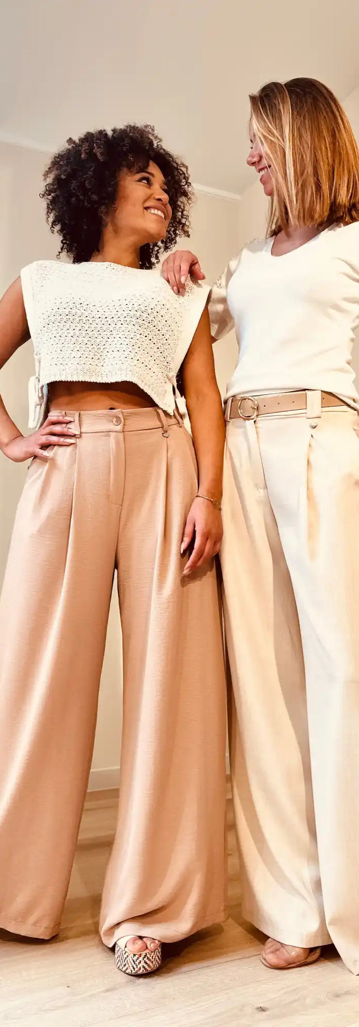 Twee vrouwen die wijde palazzo-broeken modelleren.
